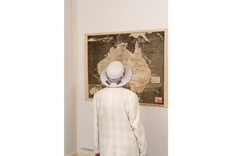 A woman views an Australian map hanging on the wall