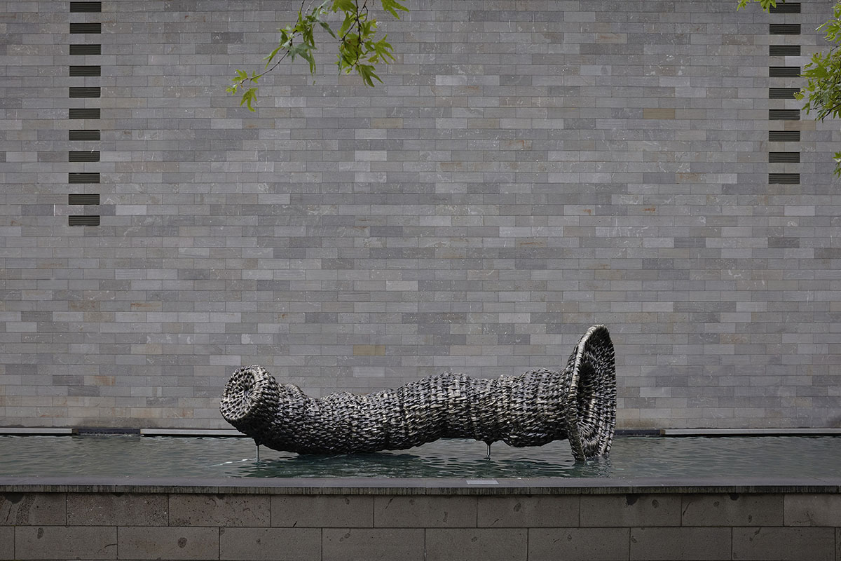 Sculpture of woven eel trap displayed in water of moat at National Gallery Victoria