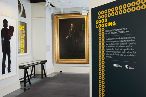 Entrance to gallery showing silhouette of a woman, large portrait and black and yellow advertising poster