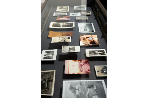19 small photos in a glass and dark wood display table