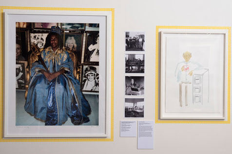 Portrait of a dark-skinned woman wearing an elaborate blue dress, four photos and a sketch of a man standing by a filing cabinet