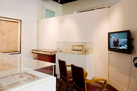 City Gallery’s south wall, with television screen display on right and glass-topped display cases