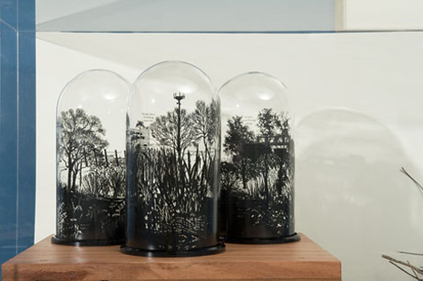 Three glass domes with black trees painted on them