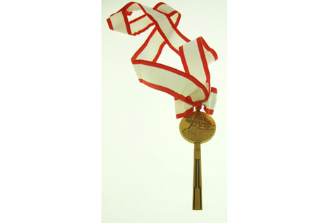 Metal key on a wide white and red-edged ribbon