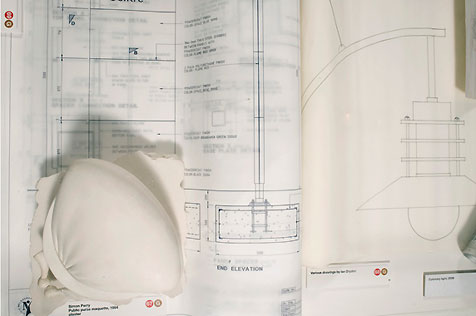 Two technical drawings, one of street lighting on the right; a plaster of Paris maquette of the street seat titled Purse sits on the left-hand drawing