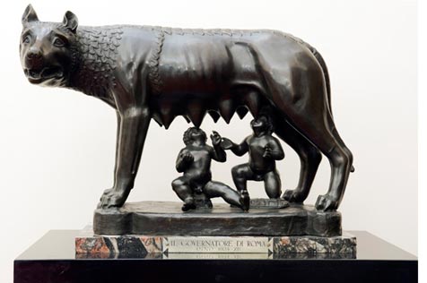 Bronze sculpture of a wolf cub suckling two infants