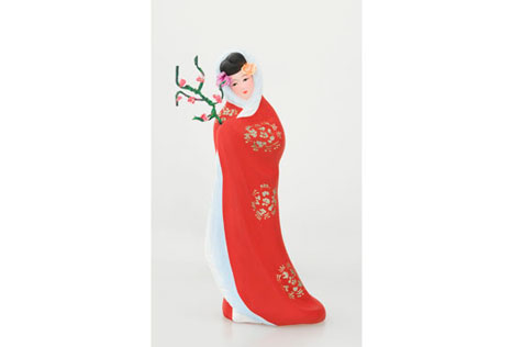 Ceramic figurine of a woman in a long red and white robe carrying a branch of pink cherry blossoms