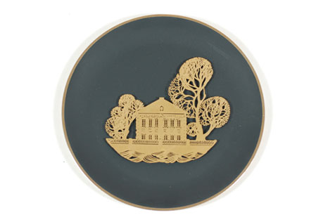 Black plate with a metal image of building and trees