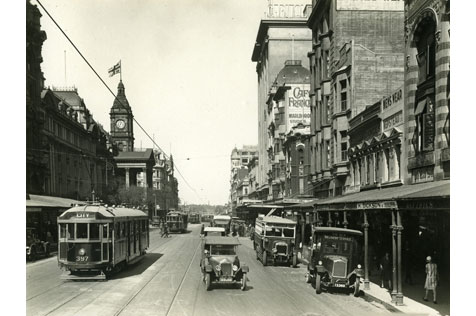 Black and white photograph of trams, cars and shops in Swanston Street circa 1930