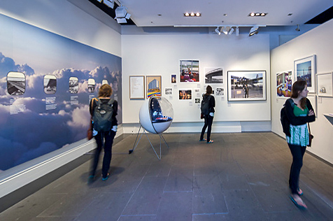 Three people looking at pictures on the gallery walls
