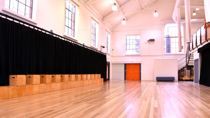 The main space is a large hall with wooden floorboards, high ceilings and natural light