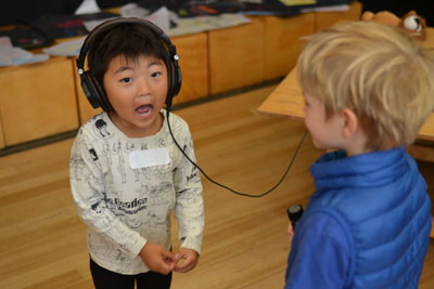 Two little boys listening to headphones.