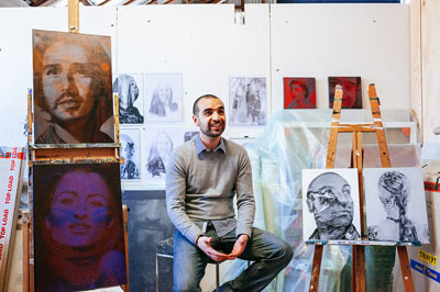 Man in artist studio space with paintings on easels