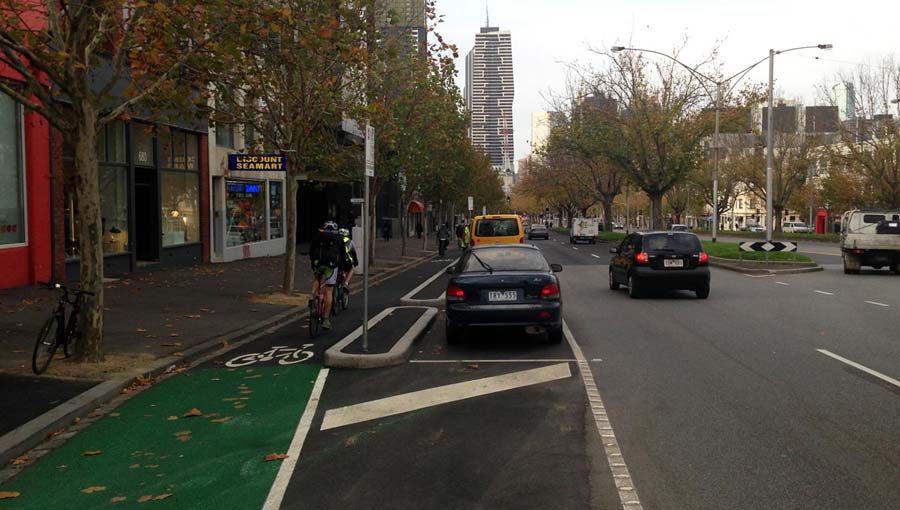 Section of the bike lane on Elizabeth Street. The lane is alongside the kerb and physically separated from parked cars and moving traffic