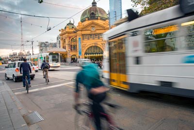 Cyclists, trams and cars at intersection near Flinders Street Station