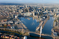 Aerial view of Docklands waterways, Bolte Bridge in the foreground and Melbourne CBD buildings in the background