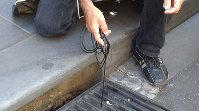 Hand lowering cable into drain