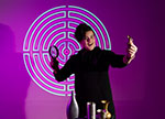 Young person gesturing in front of purple background
