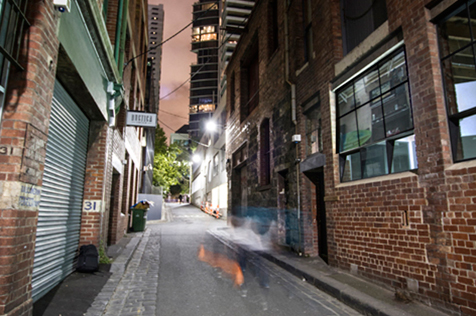 Laneway at night with blurred image of person