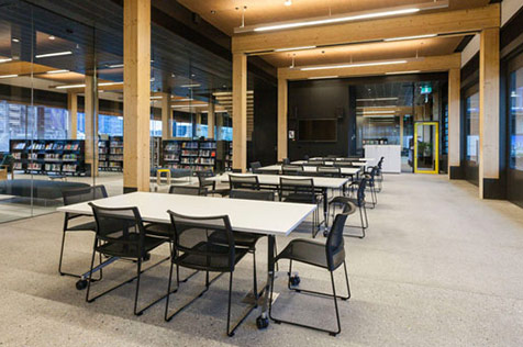 Large room set up with tables and chairs in a library