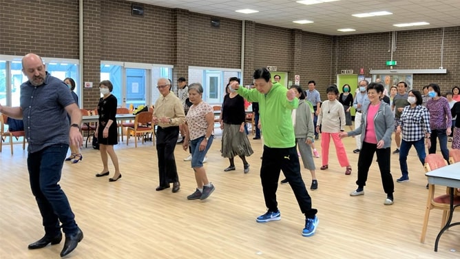 A group of line dancers in a hall