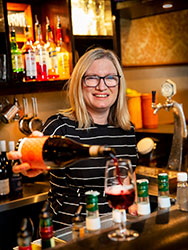 Kath Camfield pouring a glass of red wine at the Cabinet bar.