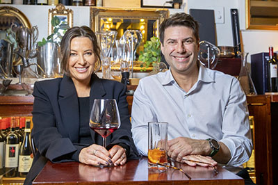 Smiling couple in restaurant with glasses of wine