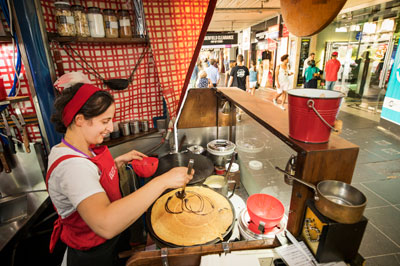 Woman making crepes in shop