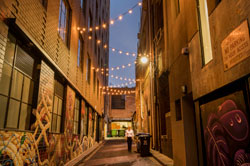 Laneway with lights strung across it.