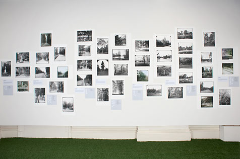 Multiple black and white photographs on a white wall