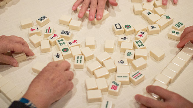 Mahjong tiles and hands on table