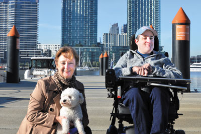 Woman with dog and man in wheelchair on pier