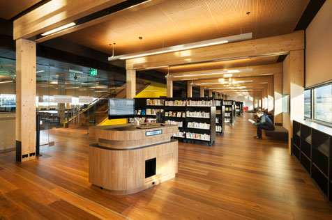 Interior of building containing book shelves, seats and counter.