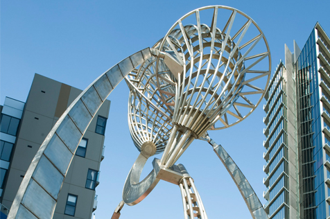 Stainless-steel sculpture among city buildings