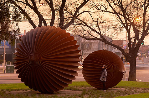 Ribbed spherical metal seed-like sculptures in park