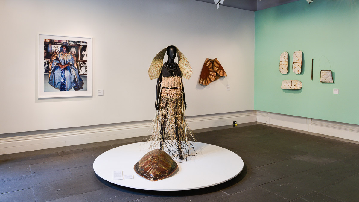 Mannequin with a headress and skirt woven from grasses and animal-skin cape on display in Recentre; sisters exhibition