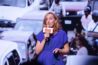 Woman with microphone in front of superimposed image