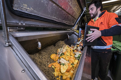 Person tipping food waste into a special bin