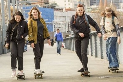 People skateboarding through a city.
