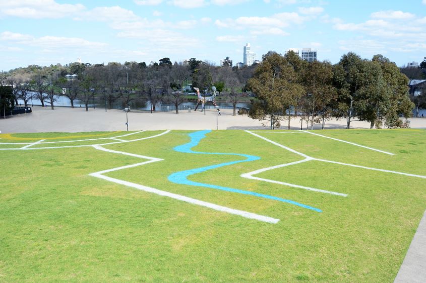Designs painted onto grassed slope in park