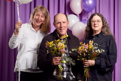 People on a stage holding flowers and balloons