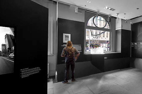 Two people viewing the walls of the Postcode 3000: a city transformed exhibition