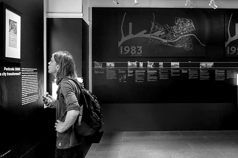Person viewing the walls of the Postcode 3000: a city transformed exhibition