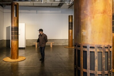 Person standing in a room with three artistic pillars around them.