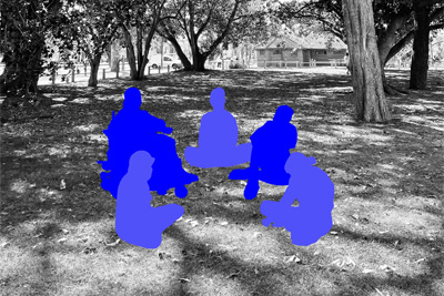 A black and white photograph with outlines of several people sitting down in a park. 