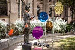 A statue stands near coloured plastic circles.