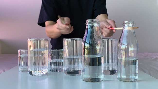 Musical instrument made from glass jars and bottles containing water and tapped with a pencil or stick