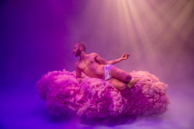 Man floating on pink and purple cloud