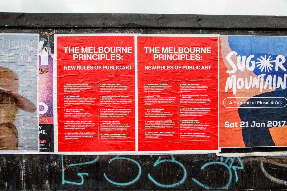 Two red posters with the New Rules for Public Art in Melbourne printed on them