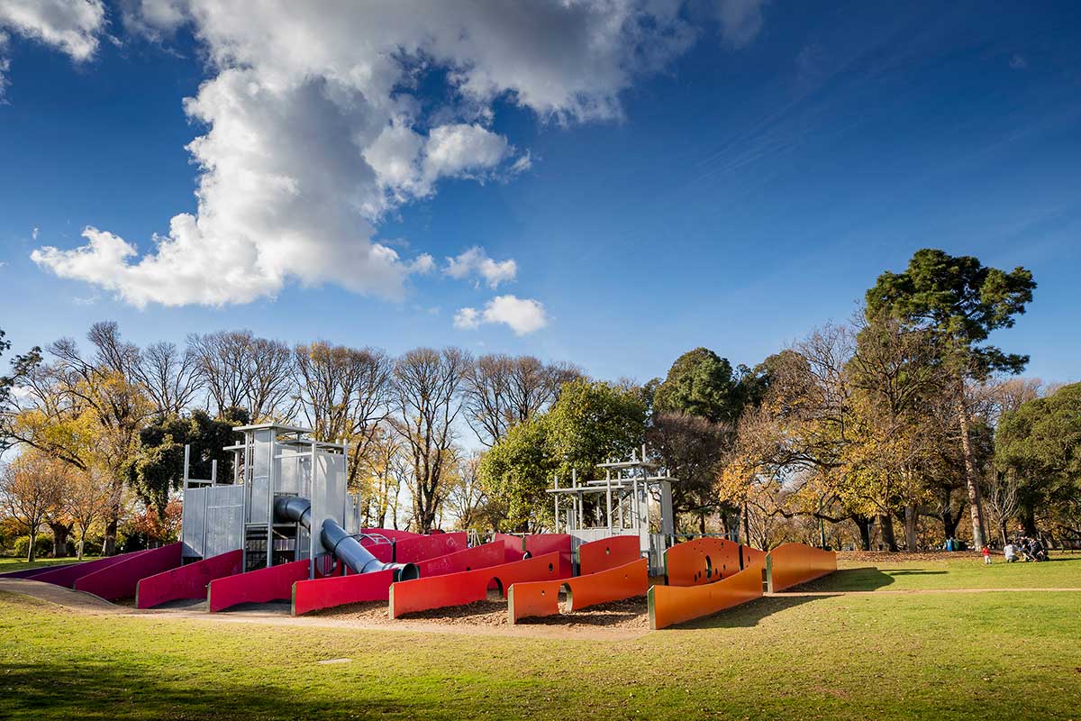 Children's playground in Carlton Gardens with a slide, climbing walls and various structures for play.